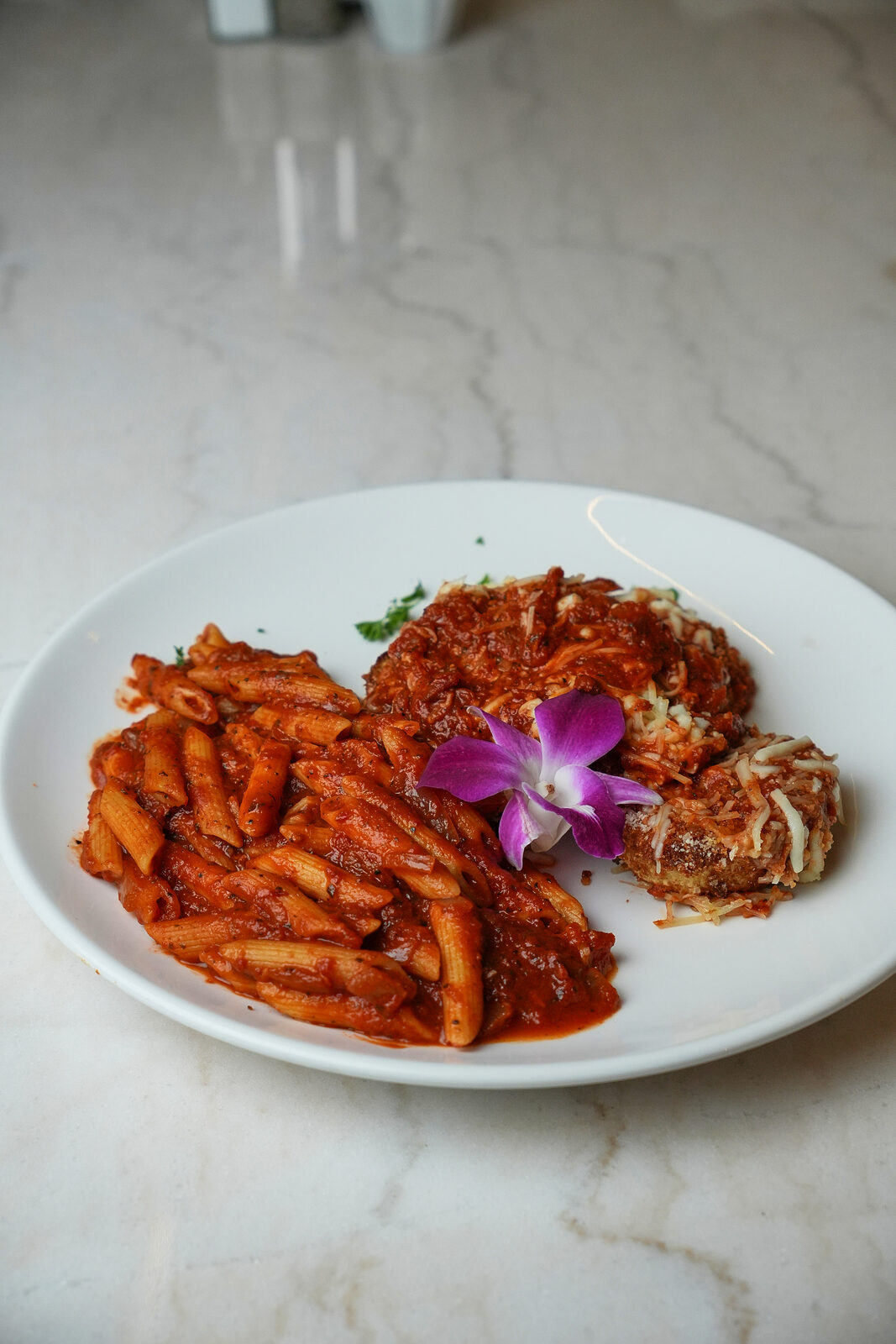 Chicken parmesan plate with penne pasta