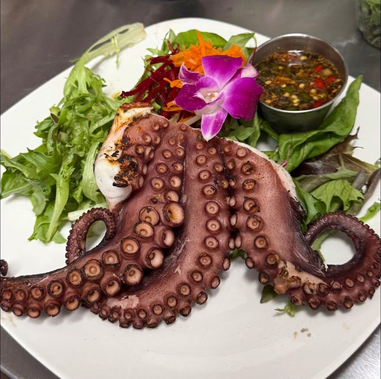 Grilled octopus with mixed greens and dipping sauce